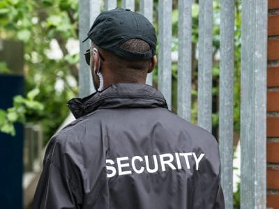 Rear View Of A Male Security Guard Wearing Black Uniform